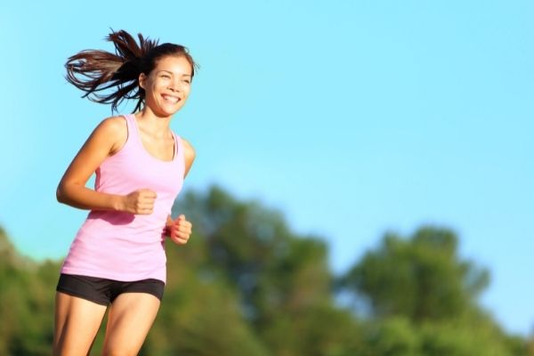 Woman running happily exercising for mental health