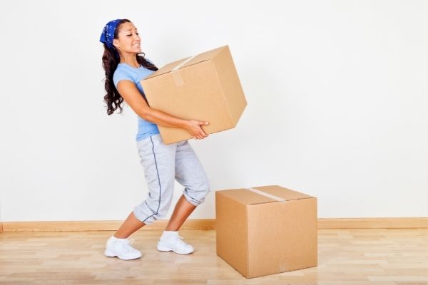 Woman carries heavy boxes after practising the active hang